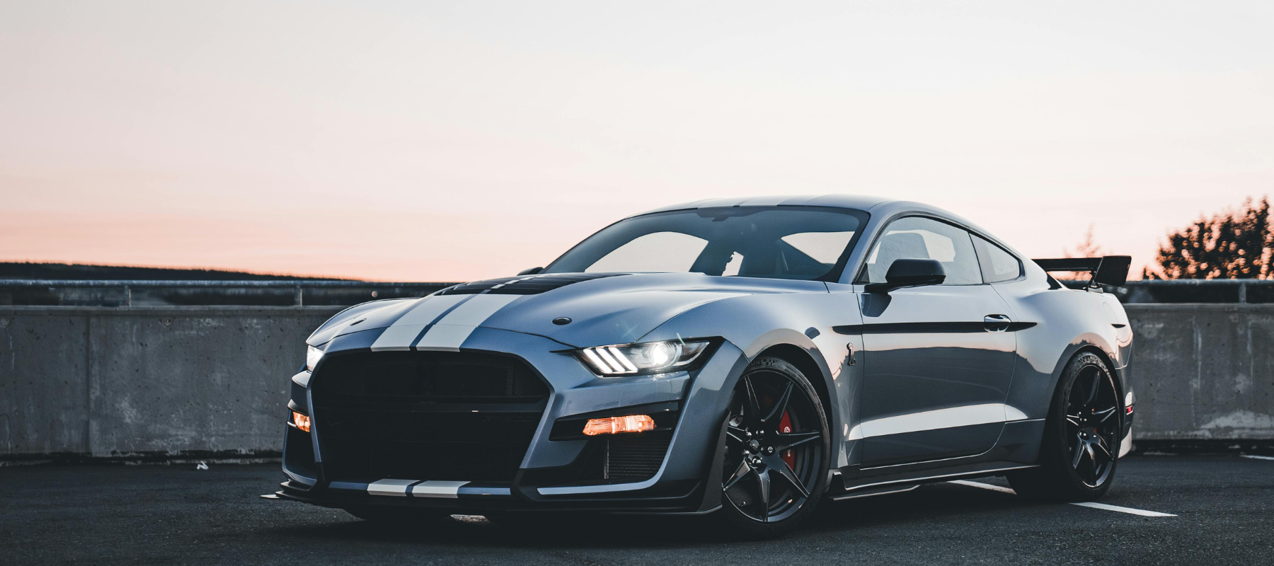 Ford Mustang GT500 – moderner amerikanischer Sportwagen bei Sonnenuntergang auf Parkdeck